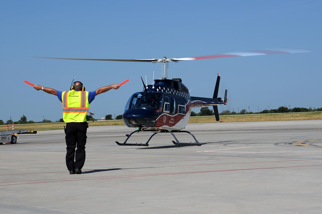 A civilian crew chief signals the Air Evac Lifeteam 34 team for takeoff at Sheppard Air Force Base, Texas, Aug. 3, 2016. Airmen from both the 82nd Civil Engineer Squadron fire department and 82nd Medical Group listen to Chris Whitmus, an Air Evac Lifeteam 34 pilot, as he trains them in preparation for Sheppard’s 75th anniversary air show celebration. (U.S. Air Force photo by Senior Airman Kyle E. Gese/Released)