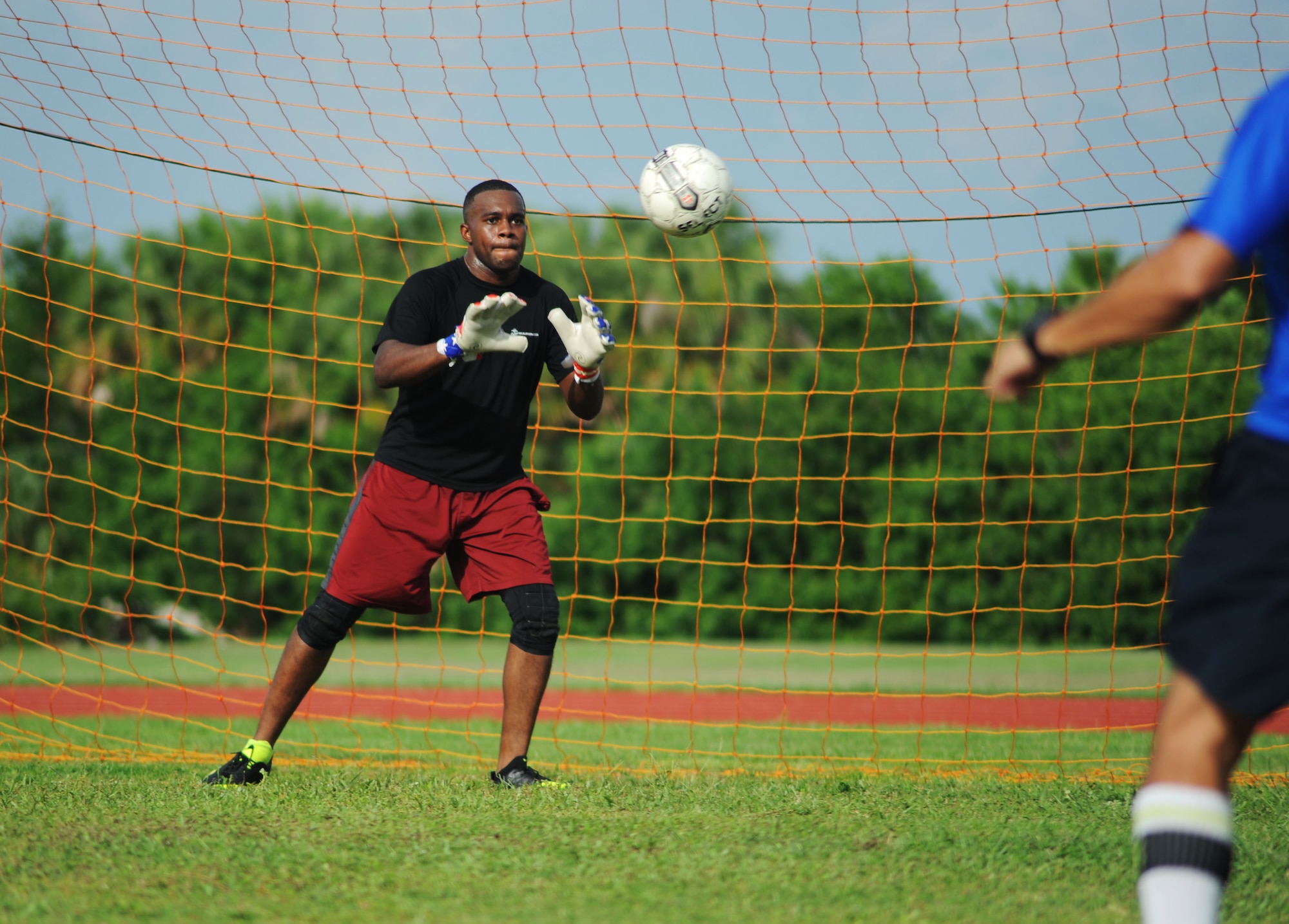 Marine Corps Lance Cpl. Devin Walker, an advance communicator assigned to U.S. Central Command prepares to block a shot during MacDill Football Club’s team practice at MacDill Air Force Base, Fla., August 3, 2016. MacDill FC has a member from each armed forces branch. (U.S. Air Force photo by Airman Adam R. Shanks)