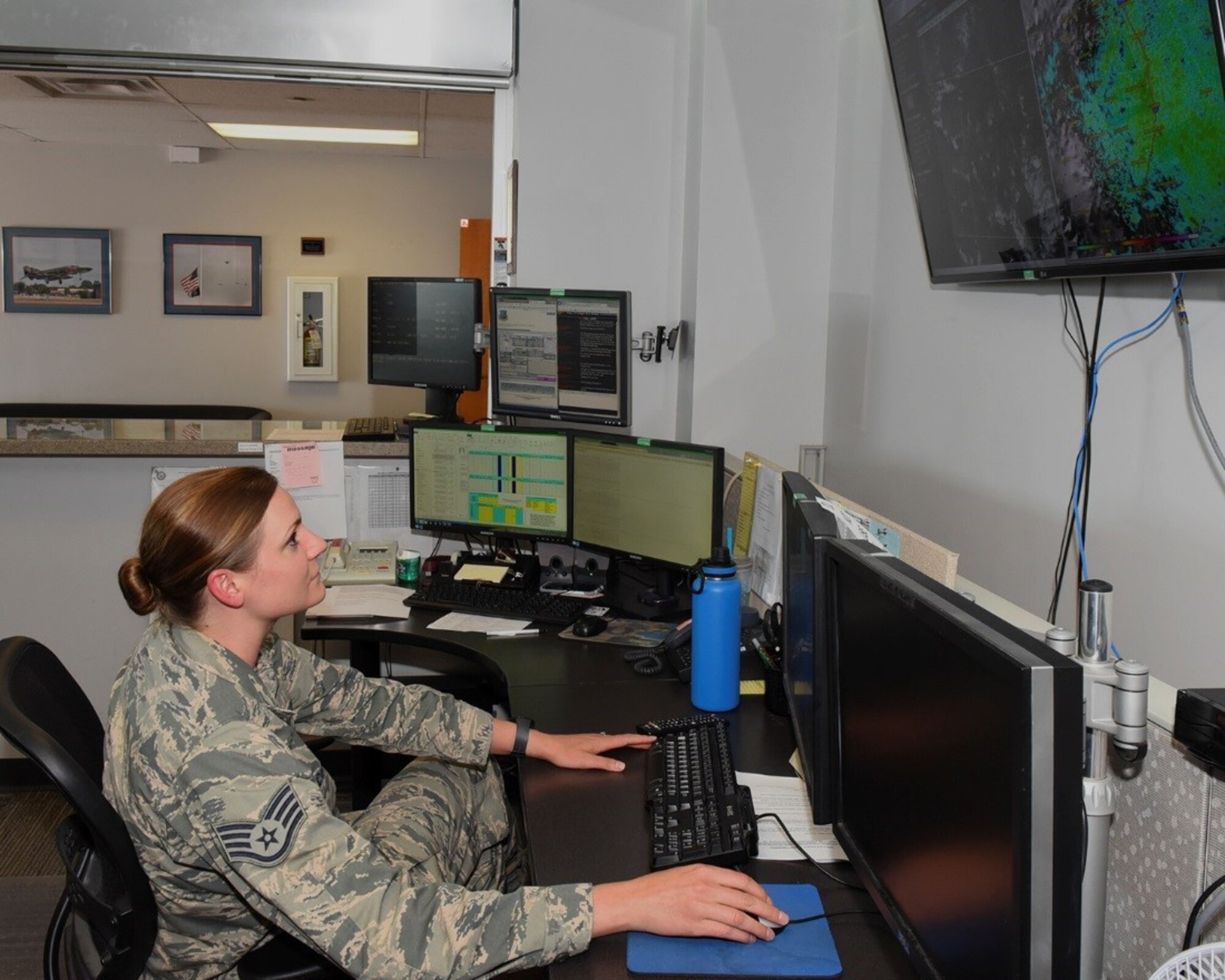 Staff Sgt. Corrine Carlson, weather forecaster for the 21st Operations Support Squadron weather flight, checks satellite imagery for future weather events at Peterson Air Force Base, Colo., Aug. 1, 2016. Carlson is one of 11 forecasters keeping base personnel notified of potential severe weather.  (U.S. Air Force photo by Philip Carter)