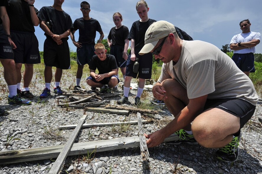 Senior Airman Casey Blackmon, a survival, evasion, resistance and escape specialist with the 1st Special Operations Support Squadron, starts a fire during a land and water survival class at Hurlburt Field, Fla., July 21, 2016. SERE specialists taught Junior Reserve Officers' Training Corps cadets how to start a fire, build a shelter and different water survival techniques. (U.S. Air Force photo by Airman 1st Class Joseph Pick)