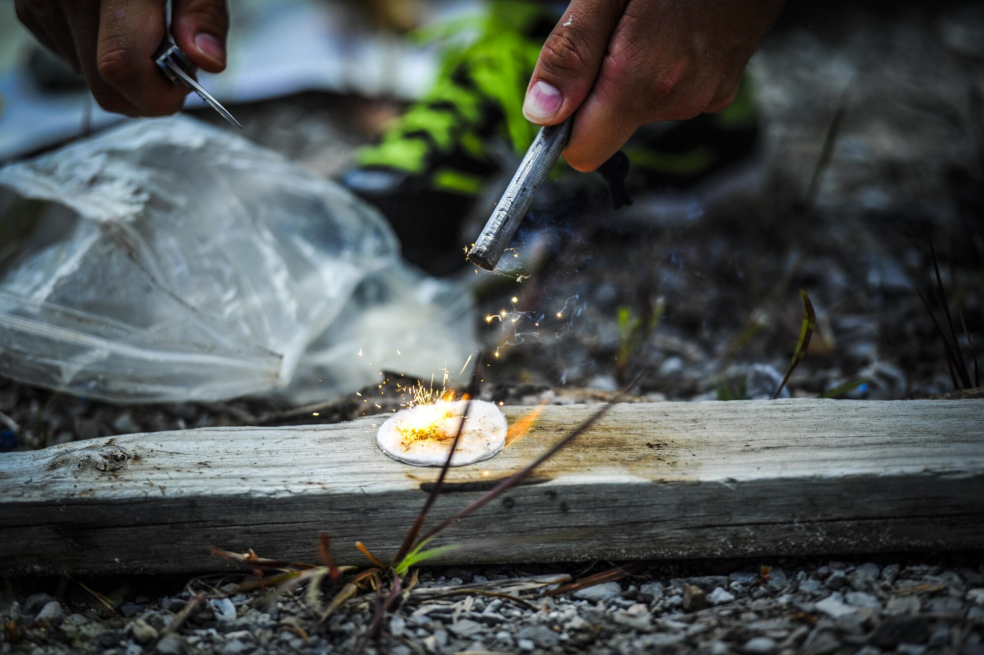 Senior Airman Casey Blackmon, a survival, evasion, resistance and escape specialist 1st Special Operations Support Squadron, ignites a fire at Hurlburt Field, Fla., July 21, 2016. SERE specialists taught Junior Reserve Officers' Training Corps cadets how to start a fire, build a shelter and different water survival techniques. (U.S. Air Force photo by Airman 1st Class Joseph Pick)