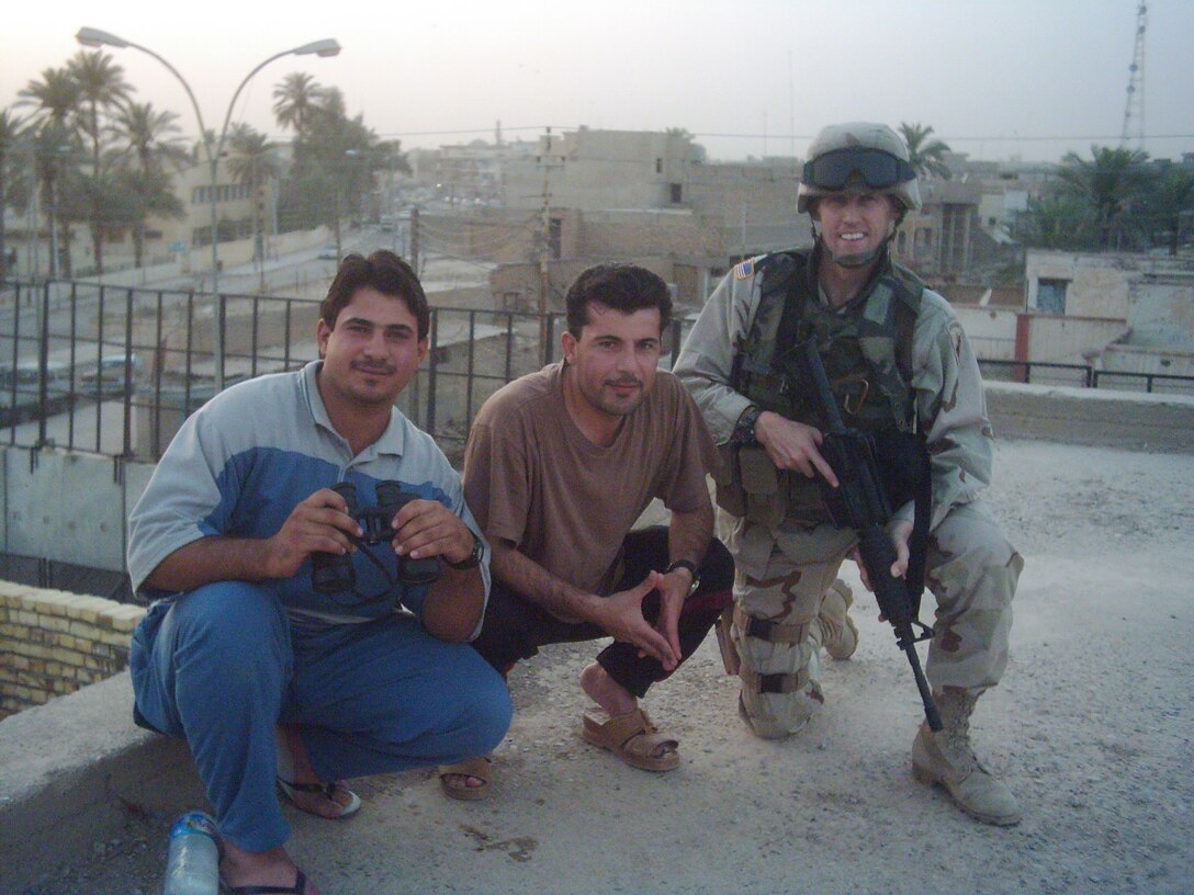 U.S. Army Reserve Sgt. Joseph Skelly with the 411th Civil Affairs Battalion takes time for a photo with local nationals on June 24, 2004 during his deployment to Baquba, Diyala Province near Baghdad, Iraq during Operation Iraqi.  Skelly later commissioned as a medical logistics officer for the 405th Combat Support Hospital and received the General Douglas MacArthur Leadership Award in D.C. on June 1, 2016.  (U.S. Army courtesy photo/released)