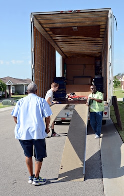 Ronald Jackson, right, a quality assurance inspector with the 72nd Logistics Readiness Squadron’s Personal Property and Passenger Movement Section, talks with members of a moving company as they prepare to load a family’s household belongings during their PCS move. (Air Force photo by Kelly White)