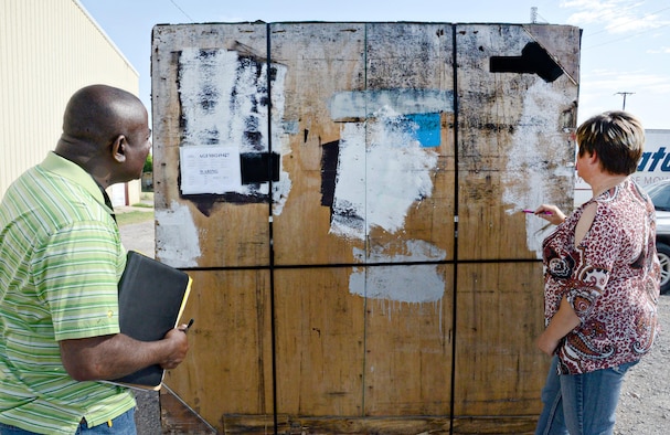 Ronald Jackson and Marsha Whitmire, quality assurance inspectors with the 72nd Logistics Readiness Squadron, inspect a moldy pallet at the business location of a local moving company. The company had received the pallet in less-than-desirable condition and immediately notified the Personal Property and Passenger Movement Section. Inspectors have to be on-site when the pallet is opened to be able to observe the condition of the contents inside and make a determination of what their next step will be. (Air Force photo by Kelly White)