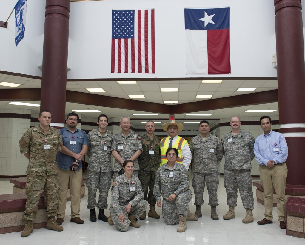 Texas Military Department service members from the Texas Army National Guard, Texas Air National Guard and Texas State Guard stand with Eduardo Olivarez of the Hidalgo County Department of Health and Human Services service members from the Chilean Army, Chilean Air Force and Chilean Navy during a military exchange and a tour of an Operation Lone Star site in Pharr, Texas, July 27, 2016. The Texas Military Department, as a part of the State Partnership Program (SPP), partners with the Chilean military and conducts numerous exchanges each year facilitating cooperation across all aspects of international civil-military affairs and encouraging people-to-people ties at the state level. OLS is an annual medical disaster preparedness training exercise, uniting federal, state and local health and human service providers, that addresses the medical needs of thousands of underserved Texas residents every year. (U.S. Army National Guard photo by Sgt. 1st Class Malcolm McClendon)