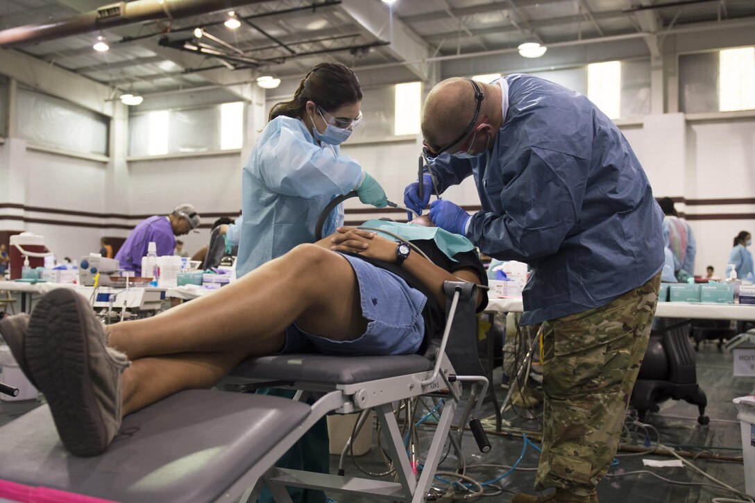 A U.S. Army Reserve dentist works alongside a civilian partner dental assistant to provide free dental services to a patient in need during an annual medical disaster preparedness exercise, July 27, 2016 in Pharr, Texas. Service members from the Texas State Guard worked alongside Soldiers from the 804th Medical Brigade, U.S. Army Reserves, the Texas Department of Public Safety, the Department of State Health Services, Remote Area Medical volunteers, Cameron County Department of Human Health Services (DHHS), City of Laredo Health Department, Hidalgo County DHHS and U.S. Public Health Services during Operation Lone Star (OLS), a week long real-time, large-scale emergency preparedness exercise in La Joya, Pharr, Brownsville, Rio Grande City and Laredo, Texas, July 25-29, 2016. OLS is an annual medical disaster preparedness training exercise, uniting federal, state and local health and human service providers, that addresses the medical needs of thousands of underserved Texas residents every year. (U.S. Army National Guard photo by Sgt. 1st Class Malcolm McClendon)