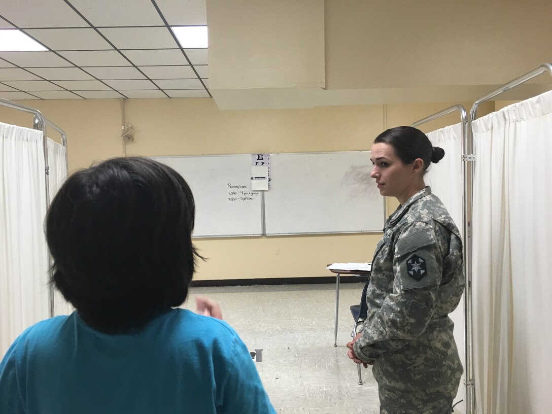 U.S. Army Reserve Sgt. Shannon Page, a health care specialist with the 399th Combat Support Hospital, has a patient read an eye chart during Operation Lone Star at Vela Middle School in Brownsville, Texas July 25, 2016.  Operation Lone Star is one of the Innovative Readiness Training events in a joint effort between the Texas Department of State Health Services, the Texas State Guard and the U.S. Army Reserve, which provides real-world training in a joint civil-military environment while delivering world class medical care to the people of south Texas from July 25-29, 2016. (U.S. Army photo by Staff Sgt. Syreeta Shaw/released)
