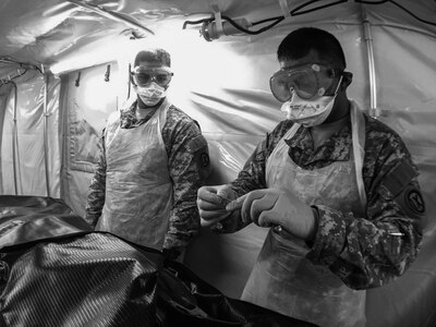 Pfc. Shawn DeVera, with the U.S. Army Reserve's 962nd Quartermaster Company (Mortuary Affairs) reads off the number on the human remains pouch tag, one final time during Mortuary Affairs Exercise 16-02, July 22, at Fort Pickett, Va. There is a constant chain of custody of human remains and personal effects with checks and rechecks all along the way even in an exercise environment. MAX 16-02 included all six U.S. Army Reserve Mortuary Affairs units performing search and recovery missions and operating Mortuary Affairs Collection Points and a Theater Mortuary Evacuation Point. The units were evaluated by active-duty mortuary affairs personnel from nearby Fort Lee, Va. (U.S. Army photo by Timothy L. Hale)(Released)