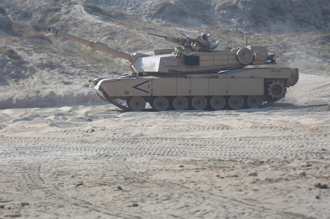 Marines with 1st Tank Battalion, 1st Marine Division move across a beach in an M1A1 tank Abrams during a Marine Corps Combat Readiness Evaluation on Camp Pendleton, Calif., August 2, 2016. After executing amphibious assault training, the Marines moved inland with high mobility multi-purpose wheeled vehicles and M1A1 Abrams tanks to reach their objective. (U.S. Marine Corps photo by Lance Cpl. Shellie Hall)