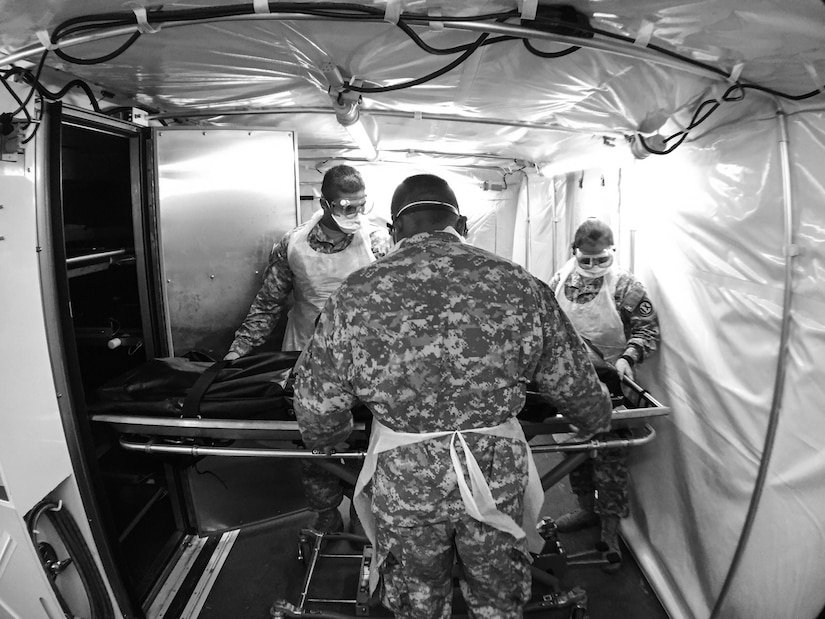 The simulated sealed human remains pouch is placed in a refrigeration unit awaiting transport to the Theater Mortuary Evacuation Point during Mortuary Affairs Exercise 16-02, July 22, at Fort Pickett, Va. MAX 16-02 included all six U.S. Army Reserve Mortuary Affairs units performing search and recovery missions and operating Mortuary Affairs Collection Points and a Theater Mortuary Evacuation Point. The units were evaluated by active-duty mortuary affairs personnel from nearby Fort Lee, Va. (U.S. Army photo by Timothy L. Hale)(Released)