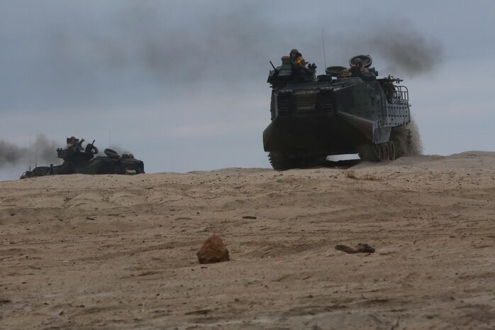 Amphibious assault vehicles move into position after emerging from the sea during a Marine Corps Combat Readiness Evaluation on Camp Pendleton, Calif., August 2, 2016. Marines with 3rd Battalion, 1st Marine Regiment, 3rd Amphibious Assault Battalion and 1st Tank Battalion worked with U.S. Navy Sailors and pilots with Assault Craft Unit 5 during the amphibious assault training. (U.S. Marine Corps photo by Lance Cpl. Shellie Hall)