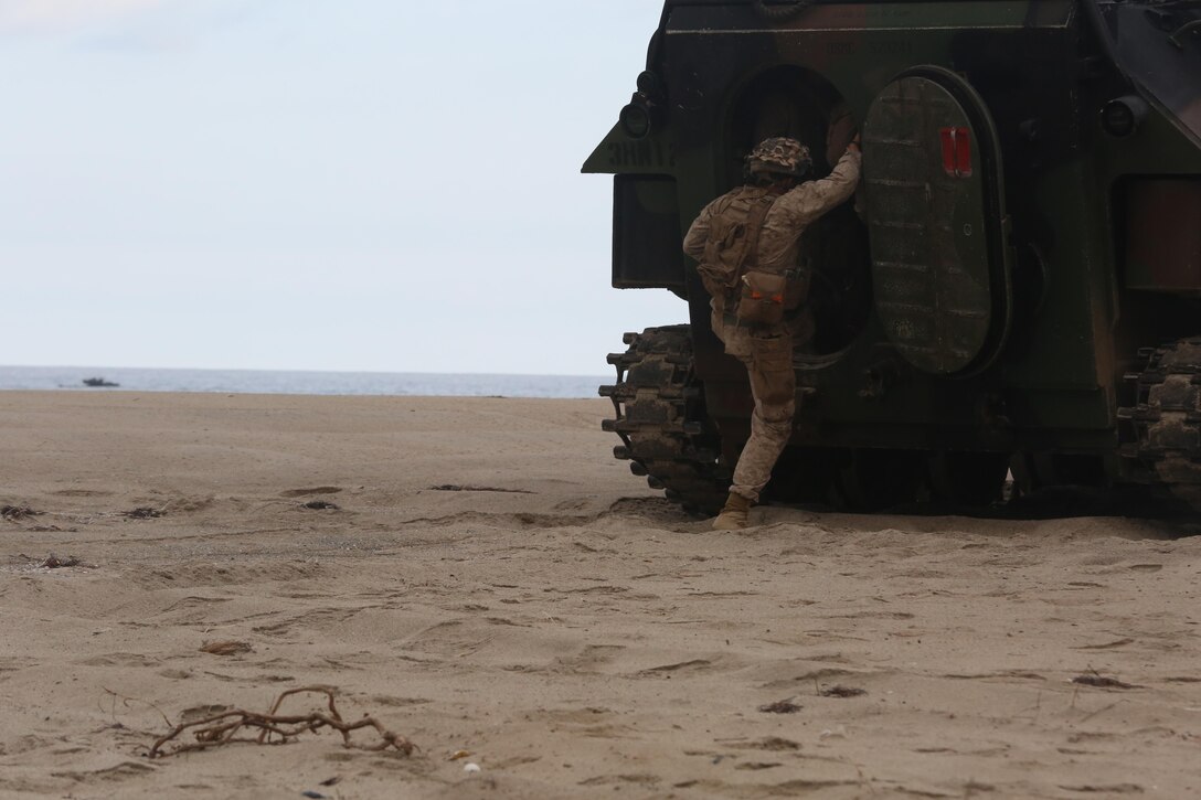 A Marine with 3rd Battalion, 1st Marine Regiment, 1st Marine Division enters an amphibious assault vehicle after providing security during a Marine Corps Combat Readiness Evaluation on Camp Pendleton, Calif., August 2, 2016. During a MCCRE, Marines perform various events to determine the combat readiness of the unit. The amphibious assault training was the last event conducted during the week long exercise. (U.S. Marine Corps photo by Lance Cpl. Shellie Hall)