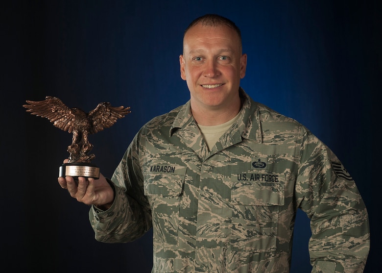 Tech Sgt Karason poses with his installation-level Force Support NCO of the Year award for Air Force. (U.S. Air Force photo by Michael Peterson)