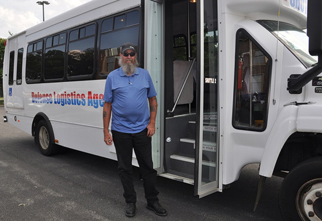 Don Matre, motor vehicle operator, Defense Logistics Agency Installation Support at Richmond, stands outside the shuttle bus he uses to transport employees around Defense Supply Center Richmond. The shuttle service is one of the many services the Customer Support Division offers to employees and visitors on DSCR. 