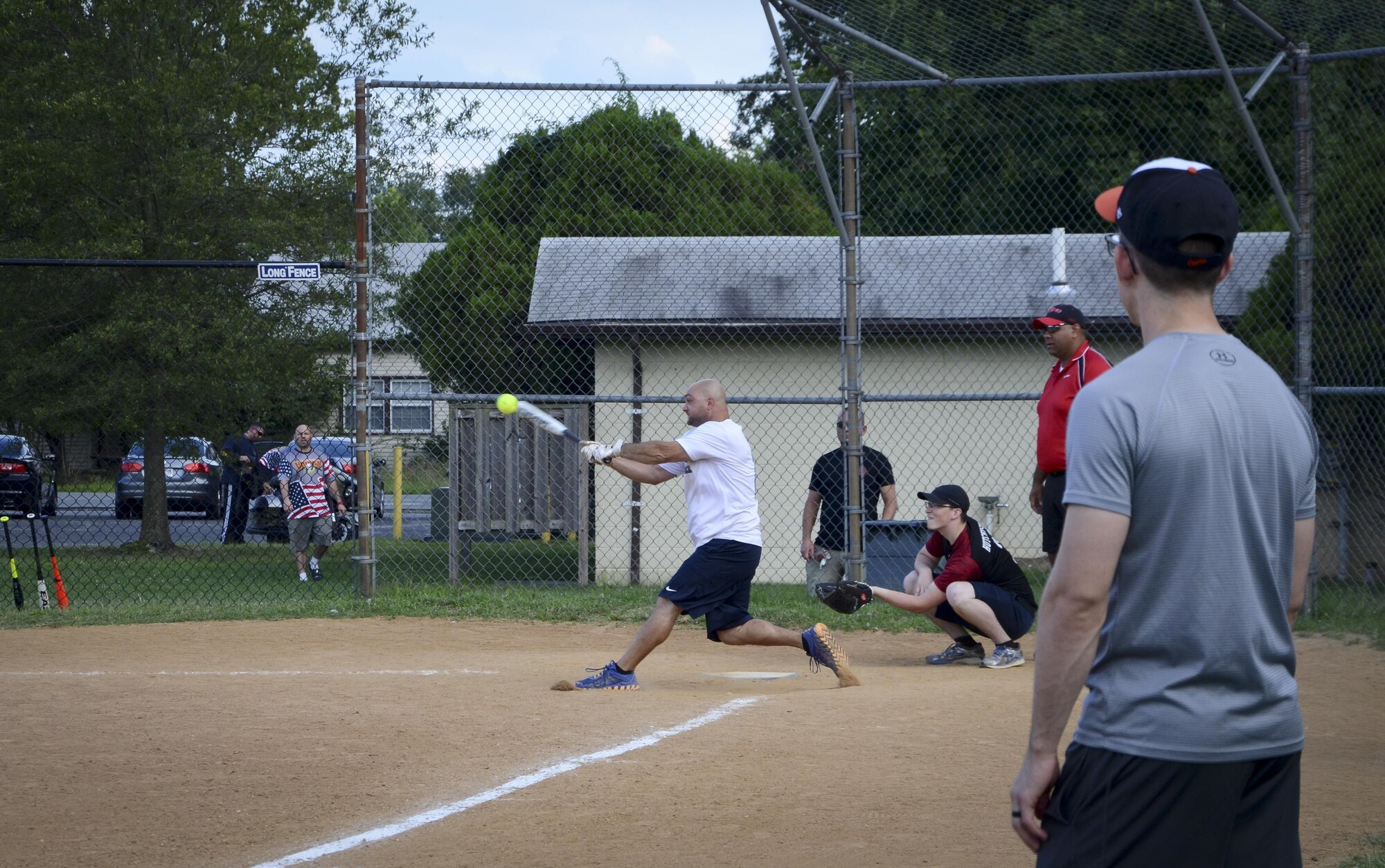A Navy Information Operations Command third base coach watches as his teammate connects with a ball during the Game 1 Division ONE Intramural Softball Championship game against the 34th Intelligence Squadron, August 3, 2016 at Fort Meade, Md. NIOC won the first game 19 to 9 to force a Game 2 against the 34th IS. (U.S. Air Force photo/Staff Sgt. AJ Hyatt)