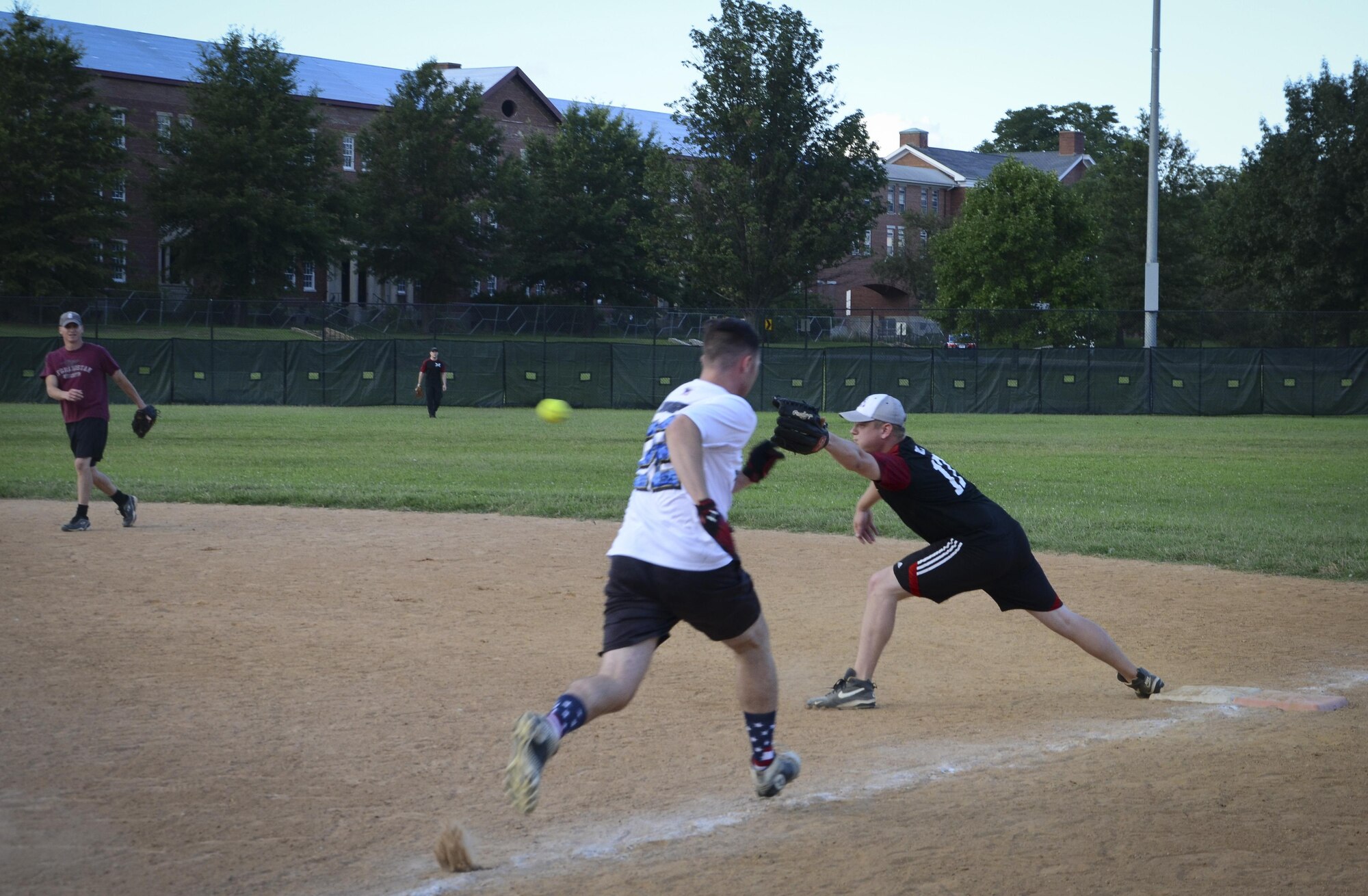 A Navy Information Operations Command player races down the first base line to beat a throw during the Game 1 Division ONE Intramural Softball Championship game against the 34th Intelligence Squadron, August 3, 2016 at Fort Meade, Md. NIOC won the first game 19 to 9 to force a Game 2 against the 34th IS. (U.S. Air Force photo/Staff Sgt. AJ Hyatt)