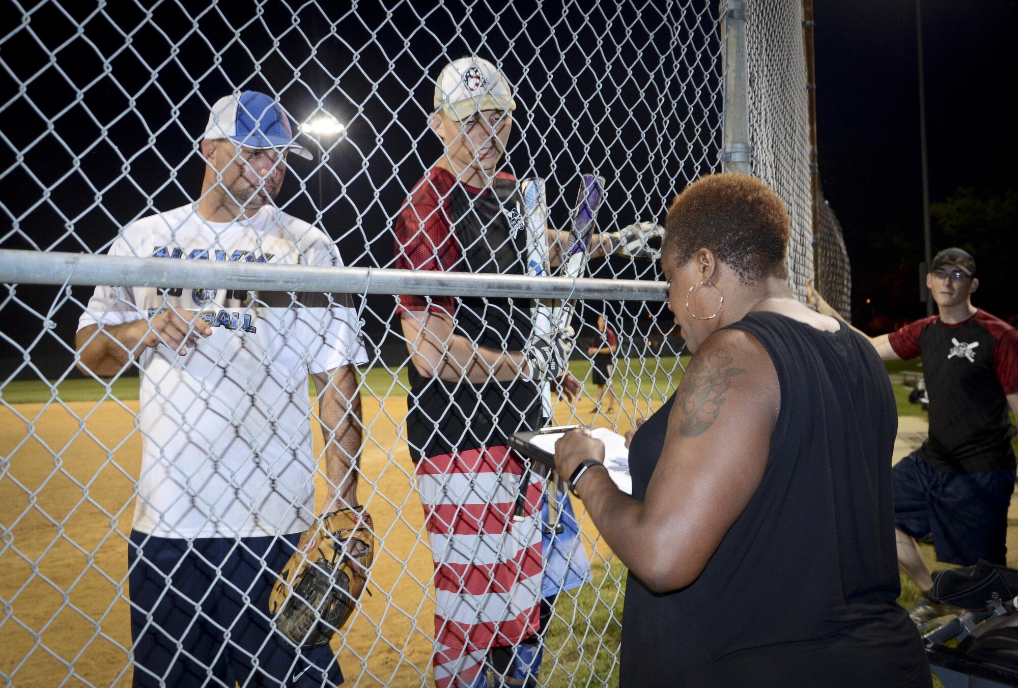 Softball players from the Navy Information Operations Command and the 34th Intelligence Squadron discuss the score with the scorekeeper during the Game 2 Division ONE Intramural Softball Championship game against the 34th Intelligence Squadron, August 3, 2016 at Fort Meade, Md. The 34th IS went on to win the Championship game 31 to 25. (U.S. Air Force photo/Staff Sgt. AJ Hyatt)