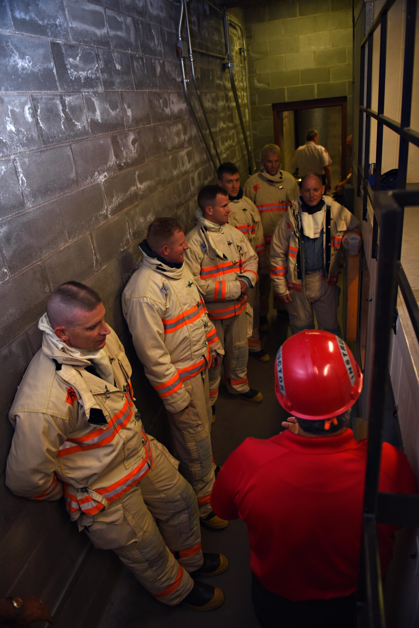 Participants listen to an instructor before entering a confinement chamber during the Fire Marshall Training at the Louis F. Garland Department of Defense Fire Academy on Goodfellow Air Force Base, Texas, Aug. 3, 2016. The confinement chamber is used to train firefighters on how to maneuver through confined spaces in full gear. (U.S. Air Force photo by Airman 1st Class Caelynn Ferguson/Released)