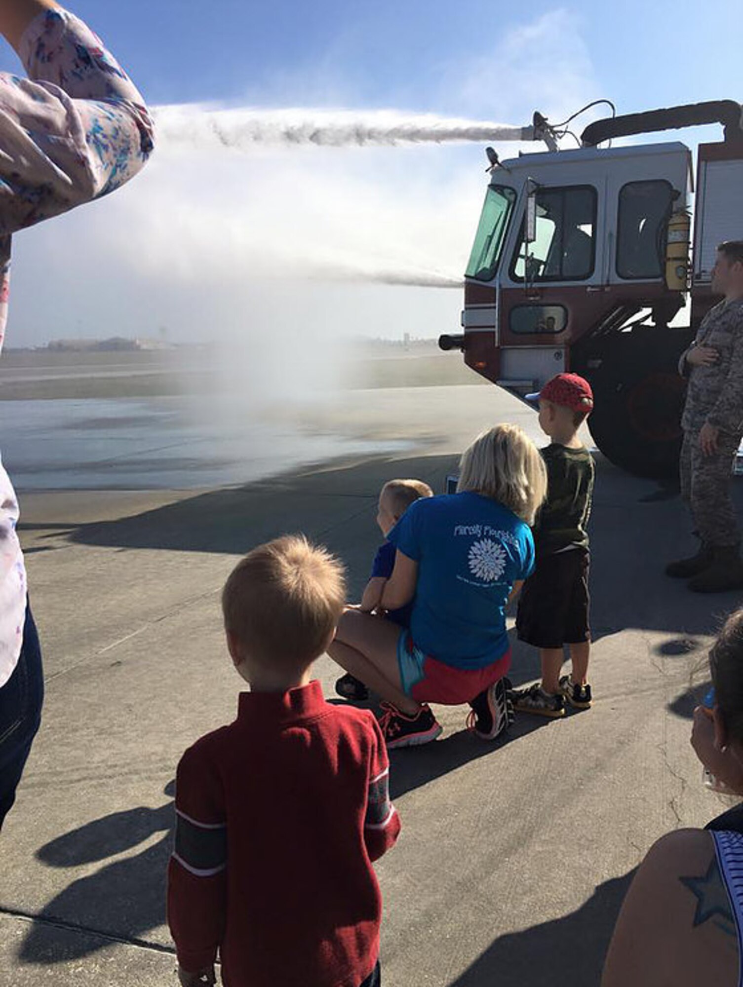 Members of MacDill Mothers of Preschoolers (MOPS) watch as the firetruck sprays water during a tour of the fire station last year at MacDill Air Force Base, Fla. MacDill MOPS begins in September and extends to April of each year. The group hosts special outings and participates in community outreach. (Courtesy Photo)