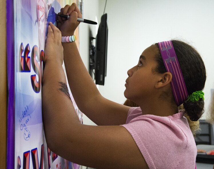 Maryam Boumahchad, 13, adds her signature to those on a pledge to fight bullying in the coming school year during Stop Bullying, Give Peace a Chance, an anti-bullying event in the Wright-Patterson Air Force Base, Ohio, Religious Education Facility Aug. 2, 2016. Boumahchad will be going to Dayton Regional STEM School as an eighth-grader this fall. (U.S. Air Force photo/R.J. Oriez)