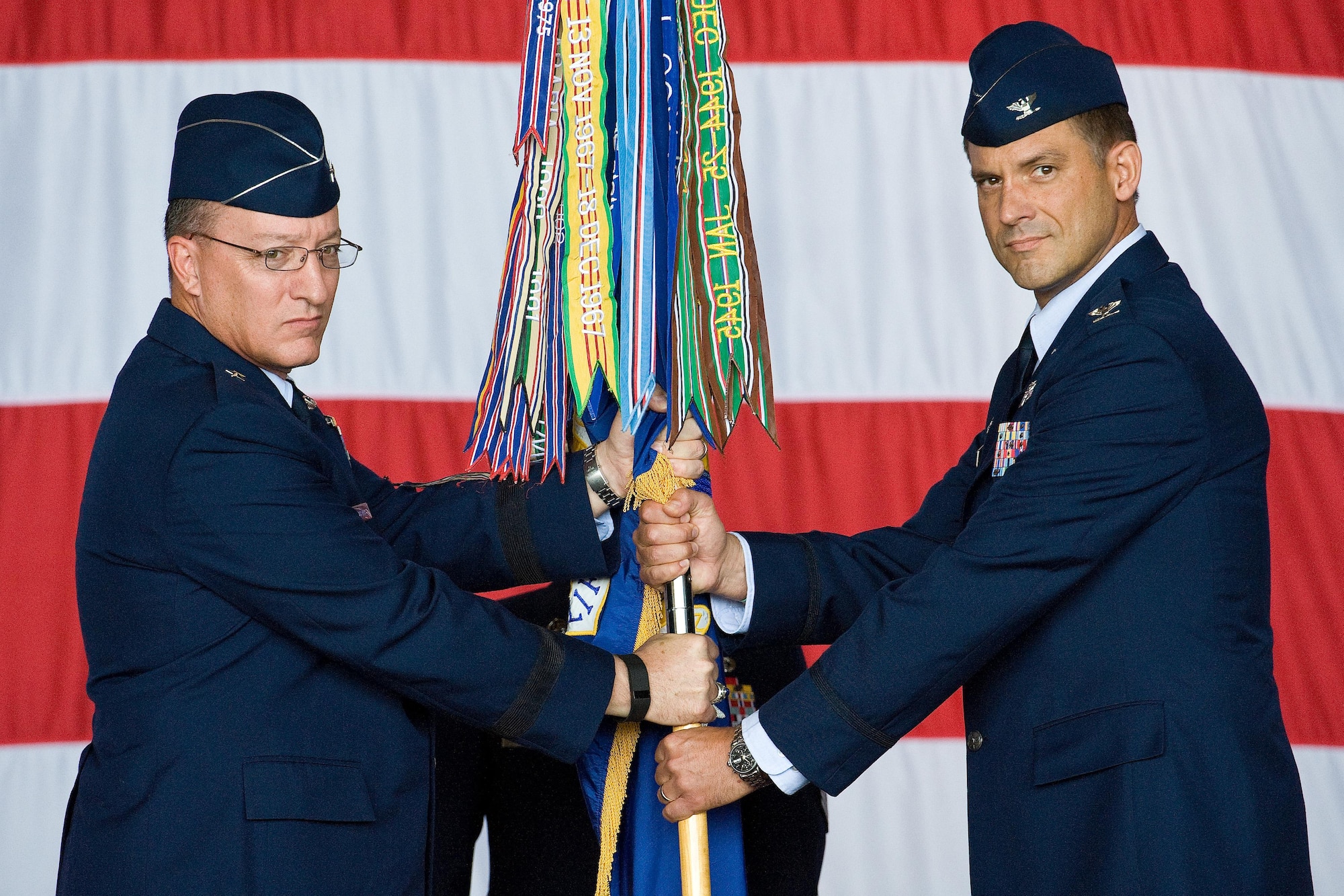 Col. Ethan Griffin, right, accepts the wing colors from Brig. Gen. Patrick Mordente, 18th Air Force vice commander, left, Aug. 5, 2016, inside Hangar 706, on Dover Air Force Base, Del. Griffin assumed command of the 436th Airlift Wing during a change of command ceremony and became 436th AW’s 33rd commander. (U.S. Air Force photo/Roland Balik)