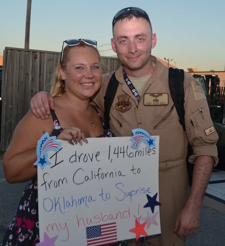The sign says it all. Staff Sgt. Alex and his wife Rebecca are reunited following his return from deployment to Southwest Asia July 21. Welcome home signs await the arrival of more than 250 members of the 552nd Air Control Wing returning to Tinker