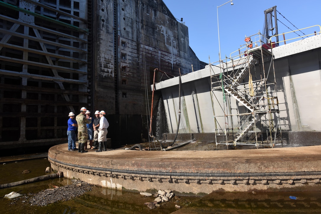 Congressman Chuck Fleischmann (Right), Tennessee District 3, huddles with U.S. Army Corps of Engineers officials Aug. 3, 2016 near the downstream miter gates inside the Chickamauga Lock chamber located on the Tennessee River in Chattanooga, Tenn. The lock is currently empty while maintainers inspect and repair the lock. The ongoing repairs make it possible to prolong the life of the lock that has been suffering from concrete expansion, which threatens its structural integrity and limits the lifespan of the lock.