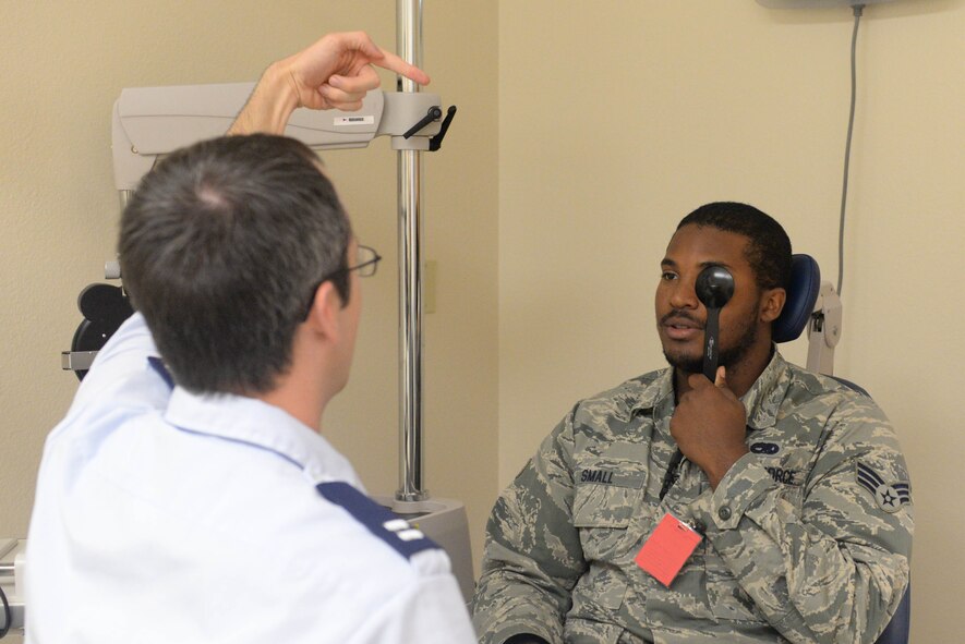 Capt. Makay Neilson, an optometrist assigned to the 5th Medical Operations Squadron, performs a peripheral vision eye exam on a patient at Minot Air Force Base, N.D., Aug. 5, 2016. This exam was part of a pre-flight physical to ensure the Airman can retrain into the flight engineer career field. (U.S. Air Force photo/Airman 1st Class Jessica Weissman)