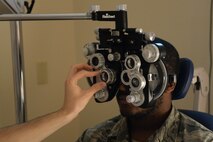 Senior Airman Lorenzo Small, an Airman assigned to the 705th Munitions Squadron, receives an eye exam at Minot Air Force Base, N.D., Aug. 5, 2016. The phoropter uses individual lenses on each eye to correct nearsightedness, farsightedness or astigmatisms in patients. (U.S. Air Force photo/Airman 1st Class Jessica Weissman)