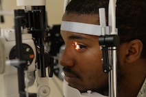 Senior Airman Lorenzo Small, an Airman assigned to the 705th Munitions Squadron, receives an eye exam using a slit lamp at Minot Air Force Base, N.D., Aug. 5, 2016. The slit lamp can identify various eye conditions. (U.S. Air Force photo/Airman 1st Class Jessica Weissman)