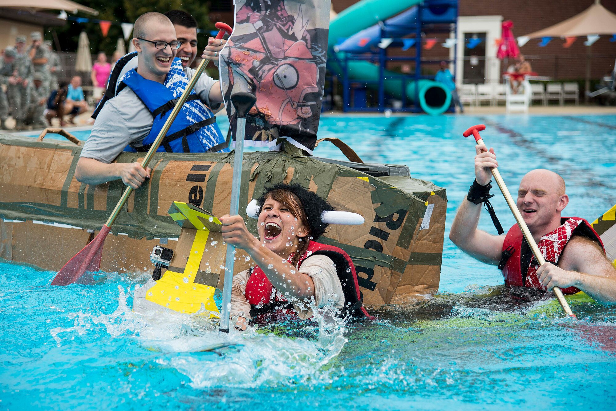 Senior Airman Megan Friedl (center) laughs as her boat sinks and is hit by another boat during the second heat of the annual boat regatta at Scott Air Force Base, Ill., Aug. 5, 2016. The other boat was manned by members of the 561st Network Operations Squadron Detachment 3. (U.S. Air Force photo by Tech. Sgt. Jonathan Fowler)