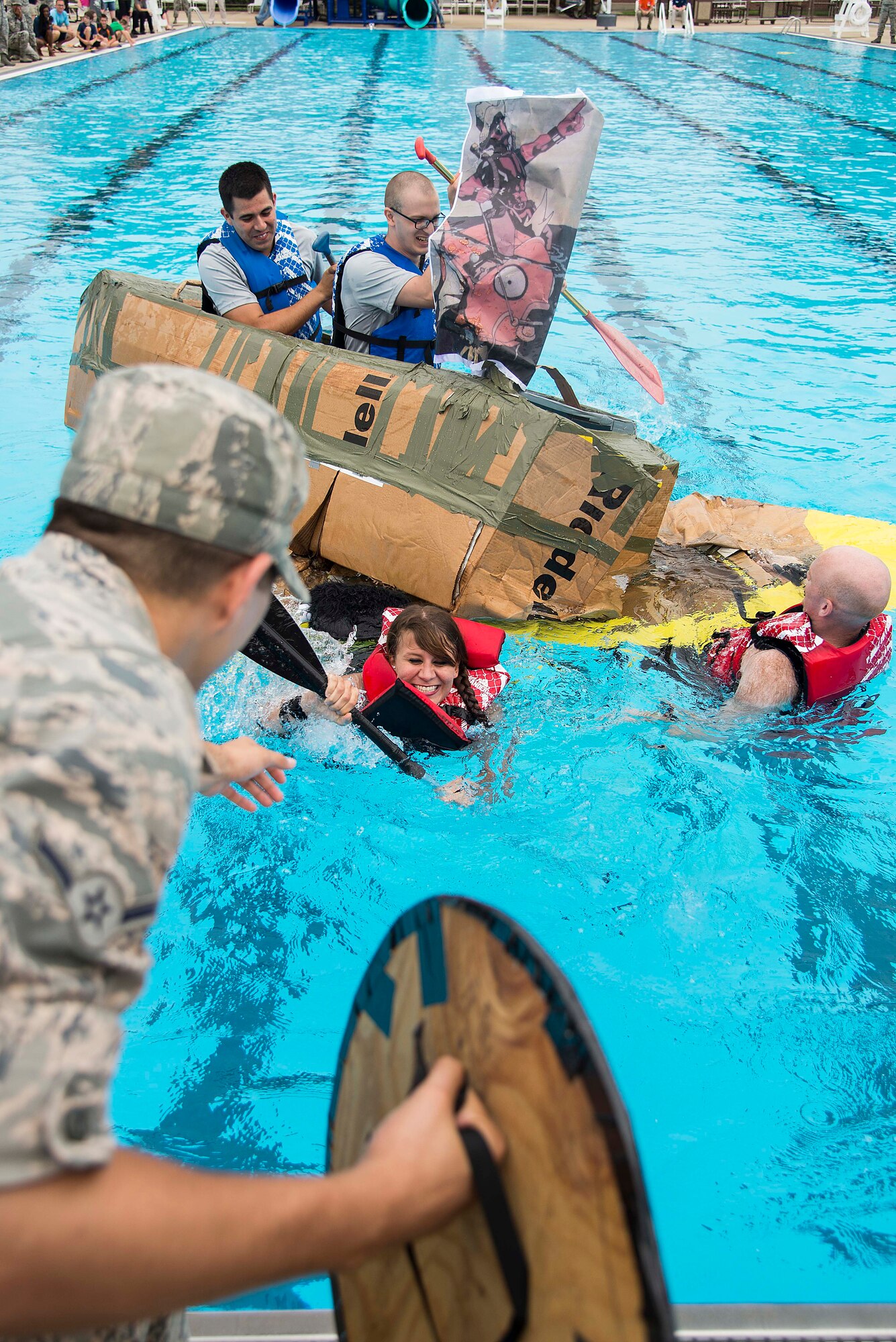Airman Daniel Garcia reaches to help Senior Airman Megan Friedl after her boat sank during the annual boat regatta at Scott Air Force Base, Ill., Aug. 5, 2016. The event featured 14 teams from a number of organizations around base. Garcia and Friedl are members of the 375th Air Mobility Wing Public Affairs Office. (U.S. Air Force photo by Tech. Sgt. Jonathan Fowler)