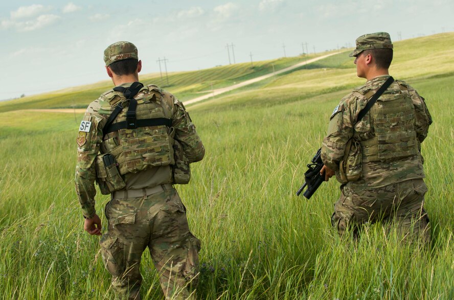 Airman 1st Class Jacob McWilliams and A1C Dalton Ramirez, 91st Missile Security Forces Squadron fire team members, perform a security sweep at a launch facility in the missile complex, N.D., Aug. 3, 2016. Security sweeps are performed to ensure there is no suspicious activity at a missile site. (U.S. Air Force photo/Senior Airman Apryl Hall)