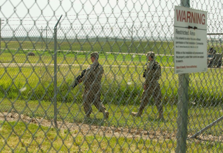 Airman 1st Class Jacob McWilliams and A1C Dalton Ramirez, 91st Missile Security Forces Squadron fire team members, perform a security sweep at a launch facility in the missile complex, N.D., Aug. 3, 2016. Security sweeps are performed to ensure there is no suspicious activity at or near a missile site. (U.S. Air Force photo/Senior Airman Apryl Hall)