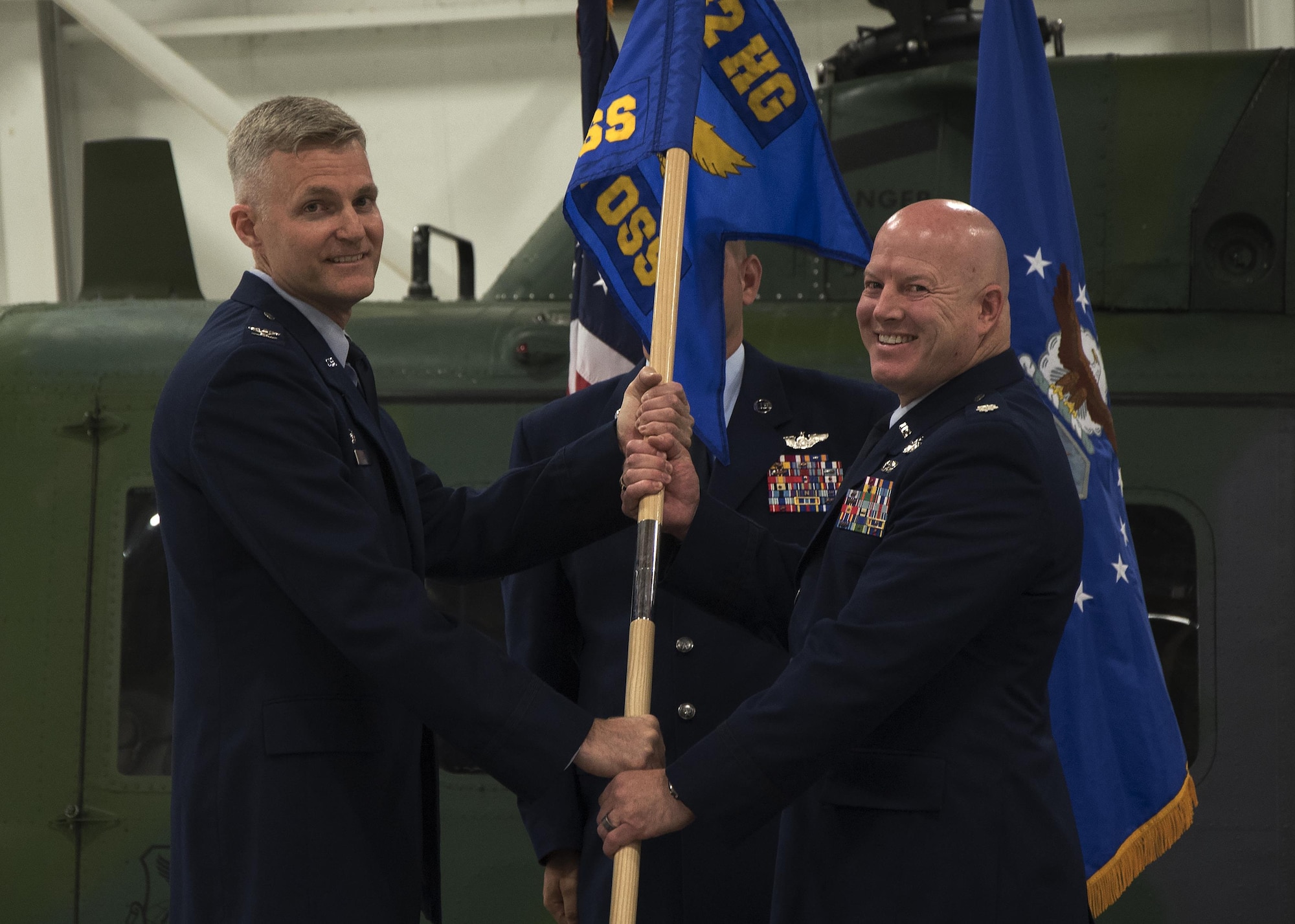 Col. David Smith, 582nd Helicopter Group commander, passes the guidon to Lt. Col. Christopher Roness, 582nd Operation Support Squadron commander, during the 582nd OSS assumption-of-command ceremony August 5, 2016, at F.E. Warren Air Force Base, Wyo. The ceremony signified the transition authority and responsibility of the squadron to Roness. (U.S. Air Force photo by Senior Airman Brandon Valle)