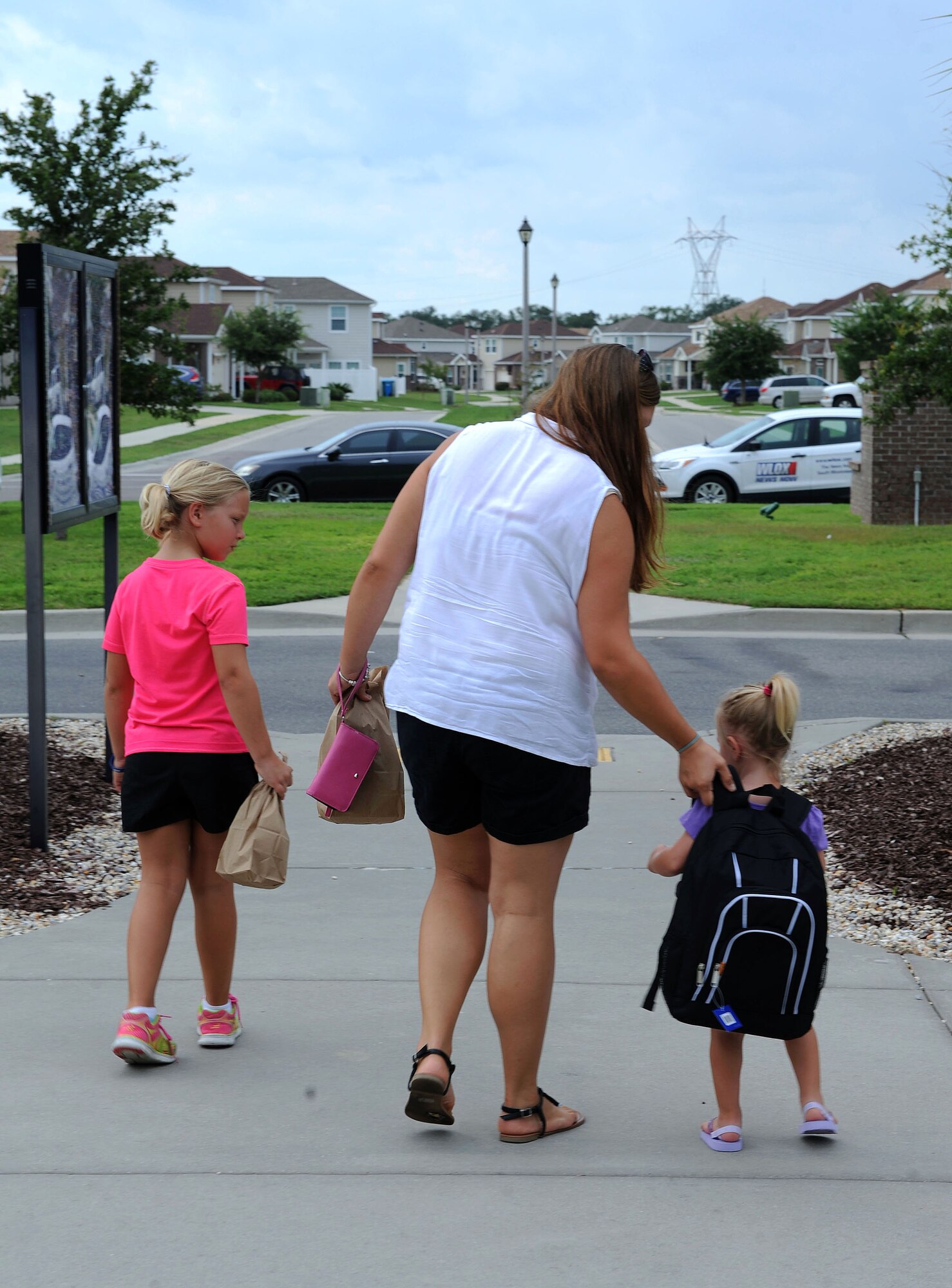 Diane Ledbetter and her daughters, Abigail and Aubrey, leave the Bay Ridge Community Center during a back-to-school event sponsored by Operation Homefront July 2, 2016, on Keesler Air Force Base, Miss. The event provided military families with backpacks and school supplies. (U.S. Air Force photo by Kemberly Groue/Released)