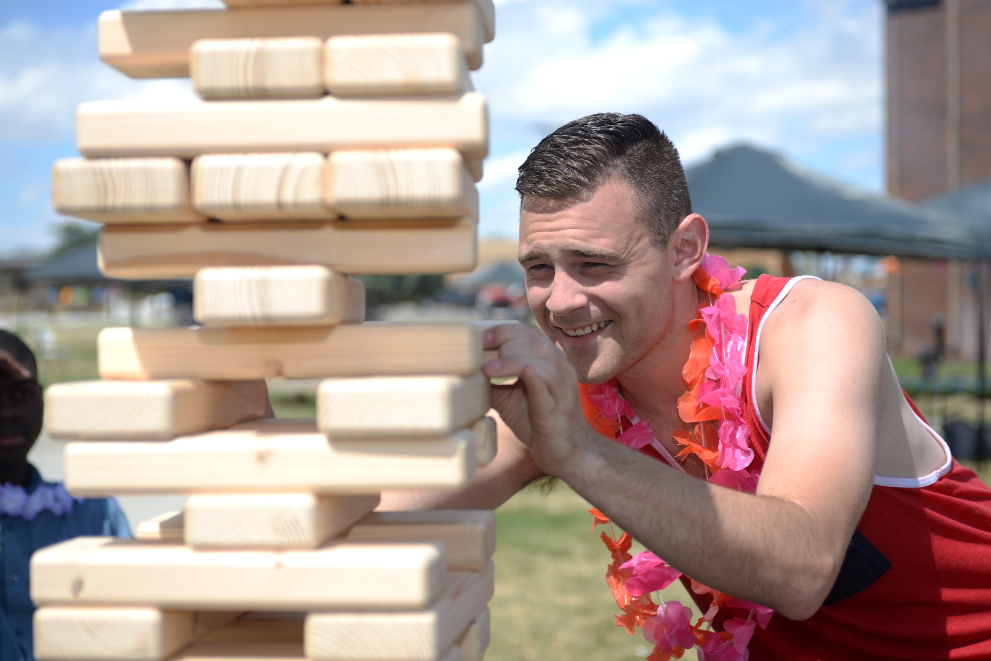 Senior Airman Austin Livengood, a communications focal point specialist assigned to the 28th Communications Squadron, slides a wooden piece out of a Jenga pile during a Summer Bash at Ellsworth Air Force Base, S.D., July 29, 2016. Airmen were able to eat free burgers and hot dogs provided by the First Sergeants Council. (U.S. Air Force photo by Airman 1st Class Sadie Colbert)