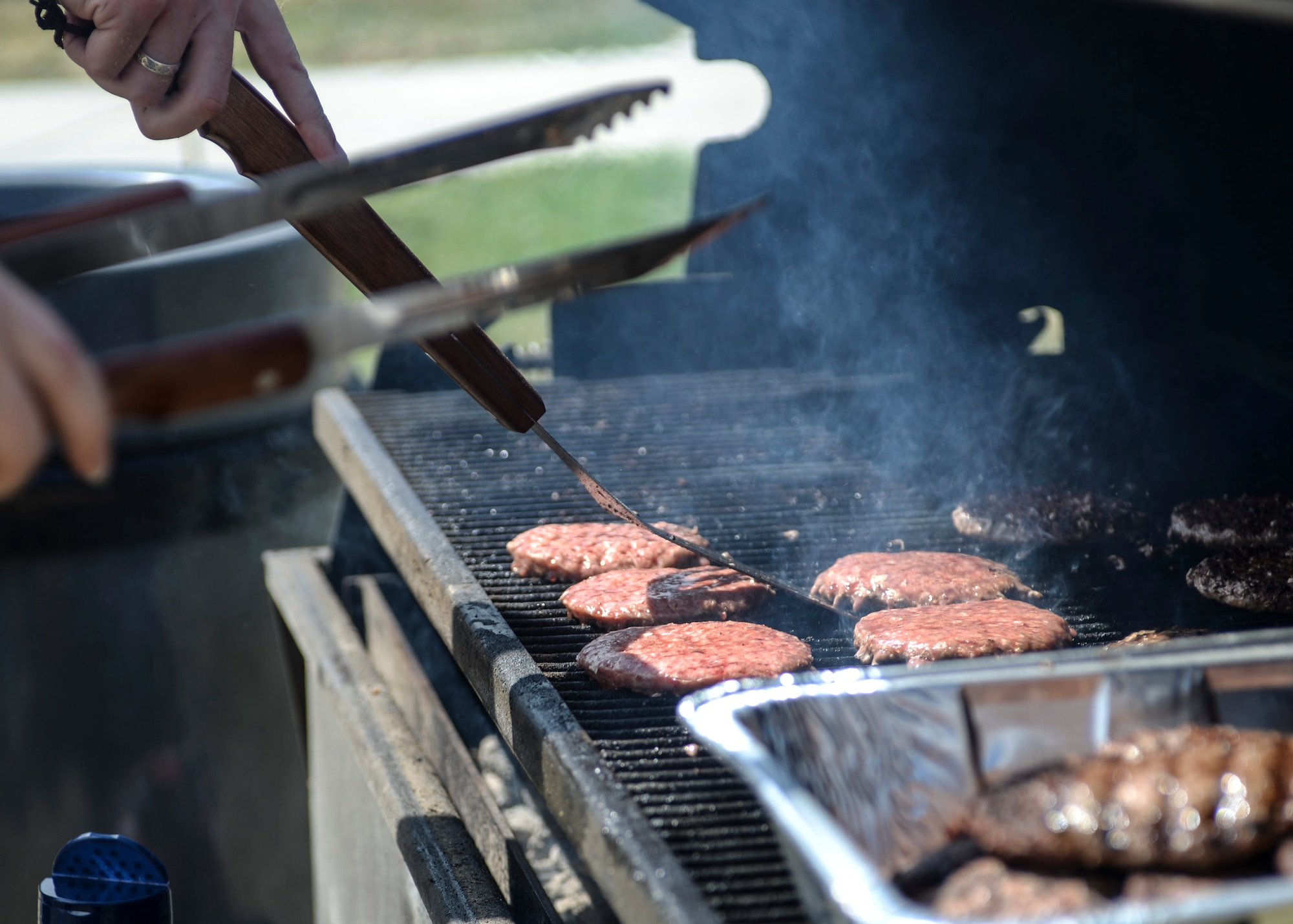 Burgers sizzle on a grill during a Summer Bash at Ellsworth Air Force Base, S.D., July 29, 2016. The Ellsworth AFB Chapel, Active Airmen’s Council and Dorm Council came together with a vision for junior Airmen and their families to attend fun event at no cost to promote morale and a spirit of comradery. (U.S. Air Force photo by Airman 1st Class Sadie Colbert)