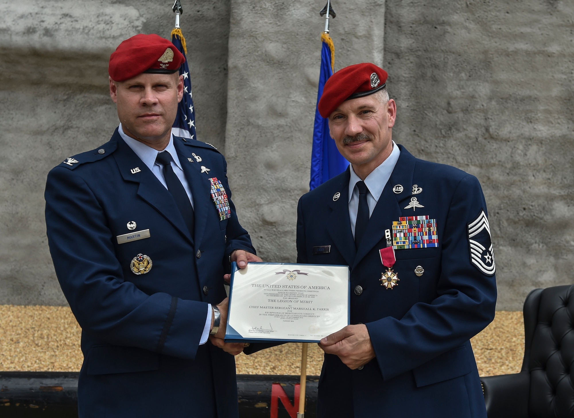 Col. Michael Martin, commander of the 24th Special Operations Wing, issues Chief Master Sgt. Marshall Farris, Headquarters Air Force combat control functional manager, a retirement certificate at the Combat Control School on Pope Army Airfield, N.C., Aug. 5, 2016. Farris deployed 12 times and participated in 33 joint-partner operations in support of combat control missions spanning a 30-year career. (U.S. Air Force photo by Senior Airman Ryan Conroy)