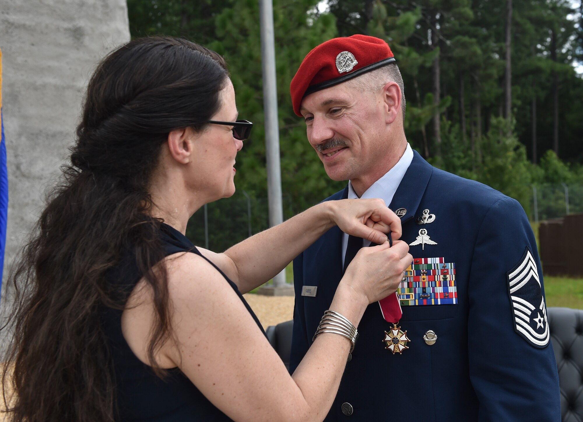 Chief Master Sgt. Marshall Farris, Headquarters Air Force combat control functional manager, receives a retirement pin from his wife during a retirement ceremony at Pope Army Airfield, N.C., Aug 5, 2016. Farris deployed 12 times and participated in 33 joint-partner operations in support of combat control missions spanning a 30-year career. (U.S. Air Force photo by Senior Airman Ryan Conroy)