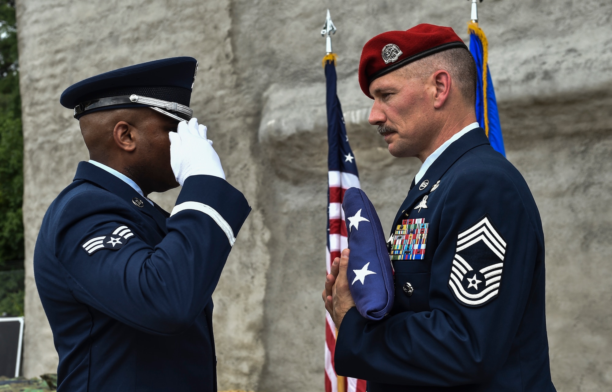 A member of the Pope Army Airfield Base Honor Guard salutes an American Flag to mark Chief Master Sgt. Marshall Farris’, Headquarters Air Force combat control functional manager, retirement during a ceremony at the Combat Control School on Pope Army Airfield, N.C., Aug. 5, 2016. As the combat control functional manager, Farris was responsible for the leadership and training of more than 600 combat control Airmen -- managing force structure, manning programs and recruiting to ensure CCT forces were available and mission ready. (U.S. Air Force photo by Senior Airman Ryan Conroy)
