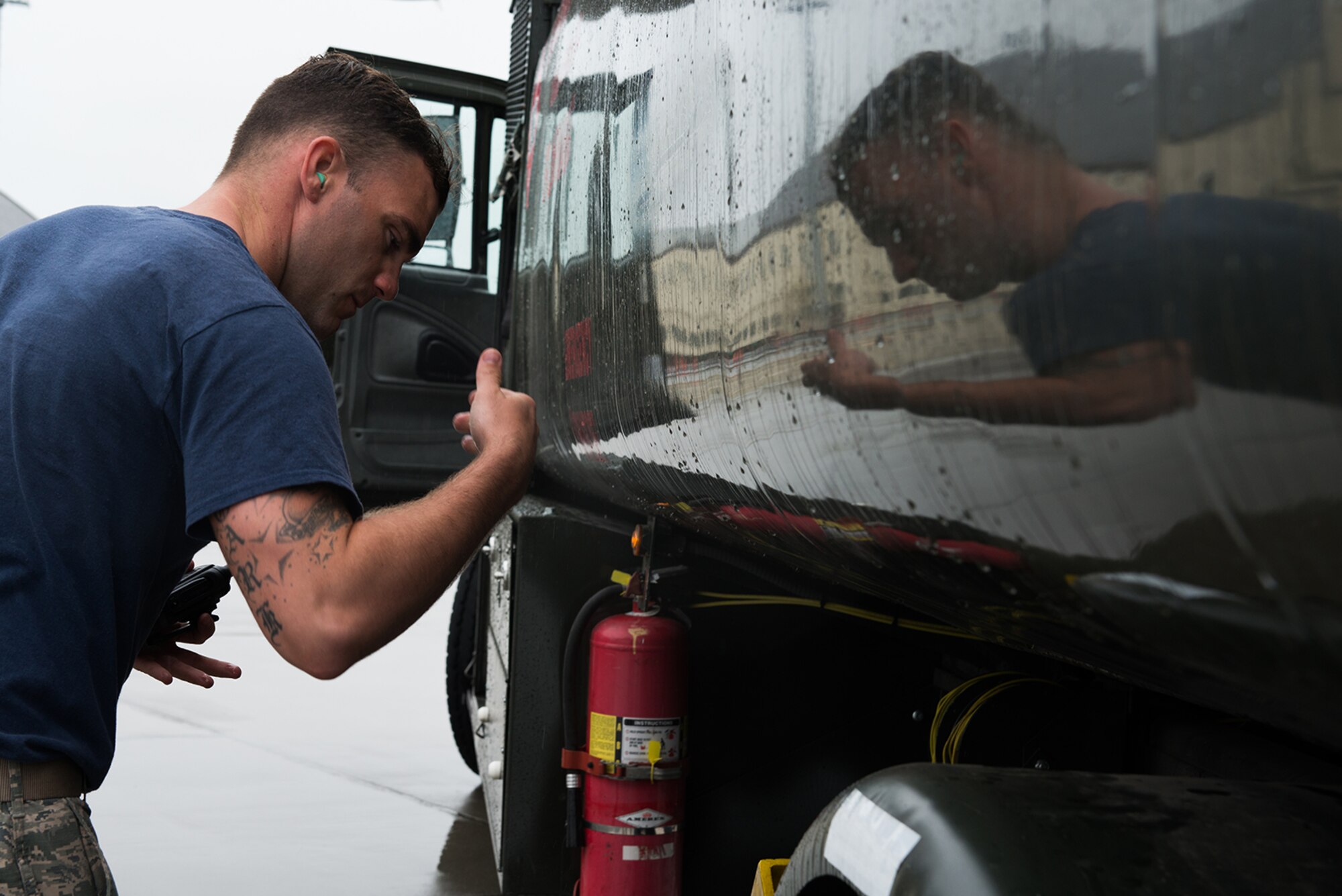Senior Airman Levi Roark, 673d Logistics Readiness Squadron, fuels distribution journeyman shakes water off his hand from removing a chock from between the wheels of an R11 fuel truck on the Joint Base Elmendorf-Richardson flightline July 22. The trucks must be chocked at all times unless someone is in the cab. 