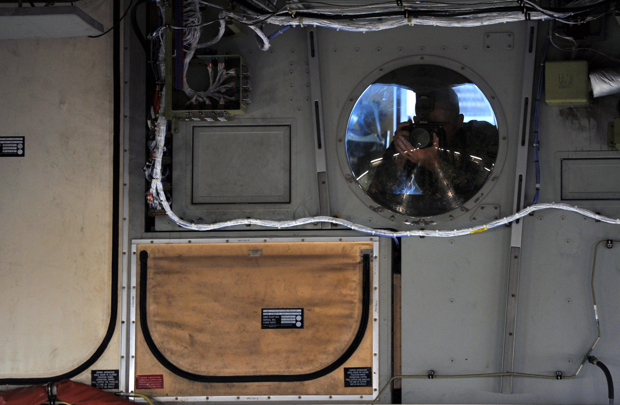 Airman 1st Class Travis Beihl, 81st Training Wing Public Affairs photojournalist, takes photos of Airmen and civilians assigned to Keesler Air Force Base, Miss., from an interior window near the cockpit of a C-17 Globemaster III from Altus Air Force Base, Okla., during an incentive flight, Aug. 4, 2016. The flight was part of a weeklong hurricane exercise to prepare Keesler for the current hurricane season. (U.S. Air Force photo by Senior Airman Duncan McElroy/Released)