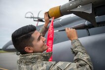 U.S. Air Force Senior Airman Christian Garibay, a 336th Aircraft Maintenance Unit weapons loader assigned to Seymour Johnson Air Force Base, N.C., removes a cover from electronic attack equipment on a U.S. Air Force F-15E Strike Eagle aircraft Aug. 5, 2016, at Eielson Air Force Base, Alaska, prior to the familiarization day of RED FLAG-Alaska (RF-A) 16-3.  RF-A training in Alaska signifies continued commitment to the Indo-Asia-Pacific area of responsibility and is vital to maintaining peace and stability in the region. (U.S. Air Force photo by Staff Sgt. Shawn Nickel)