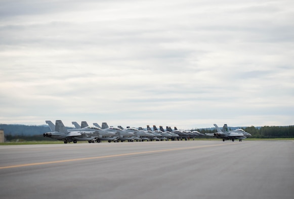 U.S. Air Force F-15E Strike Eagle dual-role fighter aircraft assigned to the 336th Fighter Squadron, Seymour Johnson Air Force Base, N.C., U.S. Navy EA-18G Growler aircraft assigned to the Electronic Attack Squadron 135, Naval Air Station Whidbey Island, Wash., and Royal Canadian Air Force CF-18 Hornet fighter aircraft assigned to the 409th Tactical Fighter Squadron, Canadian Forces Base Cold Lake, Canada, line up at the end of the runway Aug. 5, 2016, at Eielson Air Force Base, Alaska, during familiarization day of RED FLAG-Alaska (RF-A) 16-3. Free exchange of ideas between multilateral forces during RF-A enhances not just partners and sister service relationships, but also their operational efficiency. (U.S. Air Force photo by Staff Sgt. Shawn Nickel)