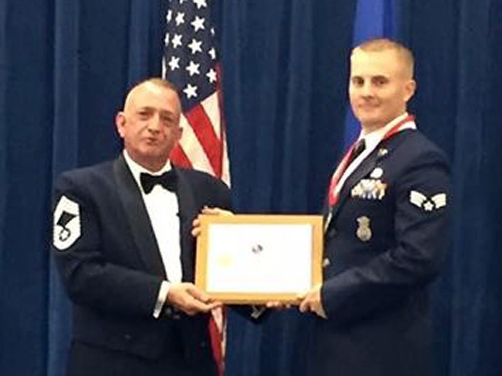 Chief Master Sgt. Andrew Traugot, chief of the Media and Engagement Division at the I.G. Brown Training and Education Center, presents 120th Airlift Wing Senior Airman Jedidiah Polk with a Distinguished Graduate Award during the Satellite Airman Leadership School graduation ceremony held at McGee-Tyson Air National Guard Base June 30, 2016. (U.S. Air National Guard photo by Chief Master Sgt. Steven Lynch)