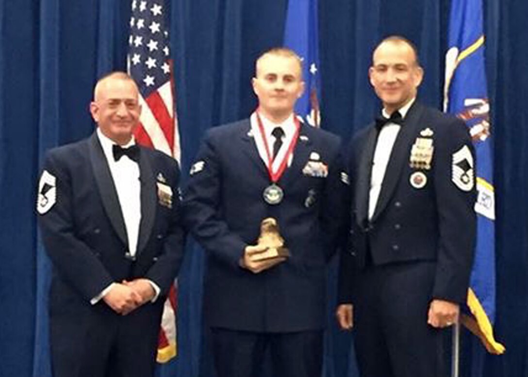 Chief Master Sgt. Andrew Traugot, chief of the Media and Engagement Division at the I.G. Brown Training and Education Center, and Chief Master Sgt. Edward L. Walden Sr., Commandant Paul H. Lankford EPME Center present 120th Airlift Wing Senior Airman Jedidiah Polk with the Academic Achievement Award during the Satellite Airman Leadership School graduation ceremony held at McGee-Tyson Air National Guard Base June 30, 2016. (U.S. Air National Guard photo by Chief Master Sgt. Steven Lynch)