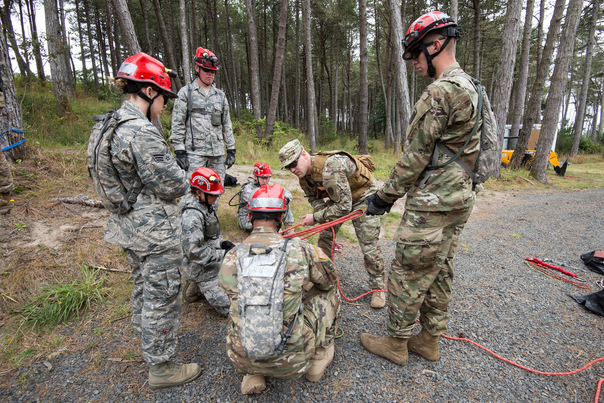 U.S. Colorado National Guard Airmen and Soldiers, assigned to the search and extraction teams (SNE) listen to an evaluator explain the method to tying rope securely around a victim being hoisted from a tall tower of rubble after a simulated chemical attack, during a joint exercise evaluation (EXEVAL) at Camp Rilea in Warrenton, Oregon, on Aug.2, 2016. The Soldiers and Airmen will practice search and extraction techniques and medical procedures to save lives in the event of a domestic emergency. (U.S. Air National Guard photo by Staff Sgt. Bobbie Reynolds)