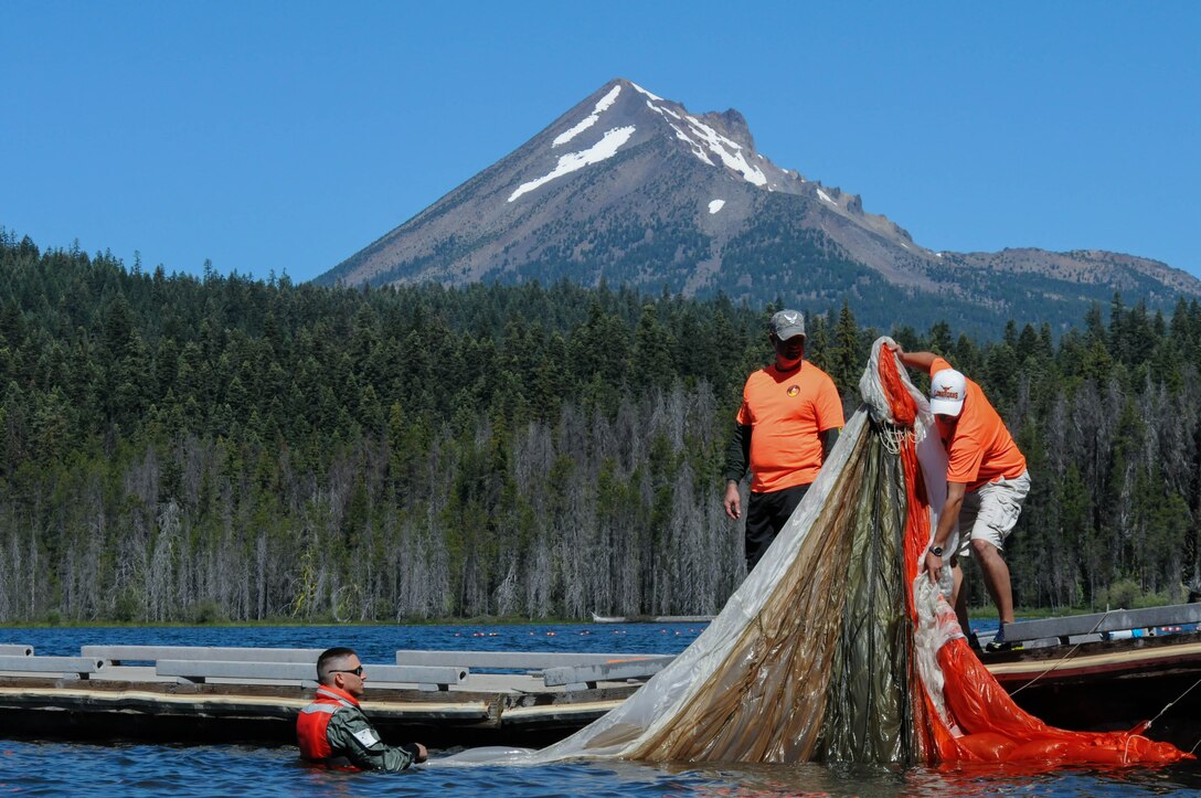 Oregon Air National Guard Master Sgt. Kenneth Shearer, 173rd Fighter Wing Aircrew Flight Equipment, extracts a water-logged training parachute from the lake during water survival training at Lake of the Woods near Klamath Falls, Ore., July 22, 2016. AFE members helped Kingsley’s F-15 pilots, providing water survival training in the event of an emergency ejection. (U.S. Air National Guard photo by Staff Sgt. Penny Snoozy)
