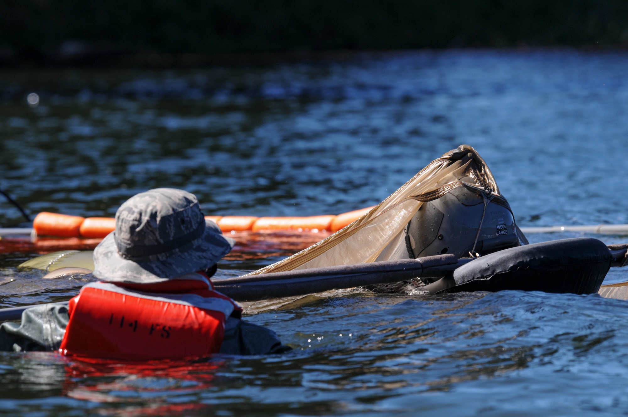 Oregon Air National Guard Staff Sgt. Thomas Howard, 173rd Fighter Wing Aircrew Flight Equipment, left, directs a pilot through a water-logged parachute during water survival training at Lake of the Woods near Klamath Falls, Ore., July 22, 2016. AFE members helped Kingsley’s F-15 pilots, providing water survival training in the event of an emergency ejection. (U.S. Air National Guard photo by Staff Sgt. Penny Snoozy)